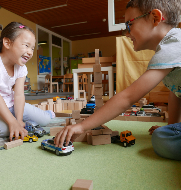 Bild Siloah Kindertagesstätten, Kindergartengruppen, Zwei Kinder spielen mit einem Auto und Bauklötzen